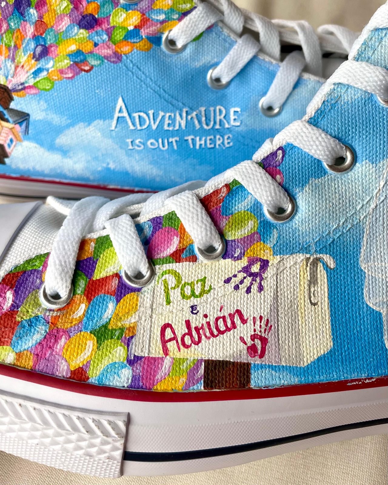 Detalle de zapatilla pintada a mano con globos de colores y los nombres de los novios